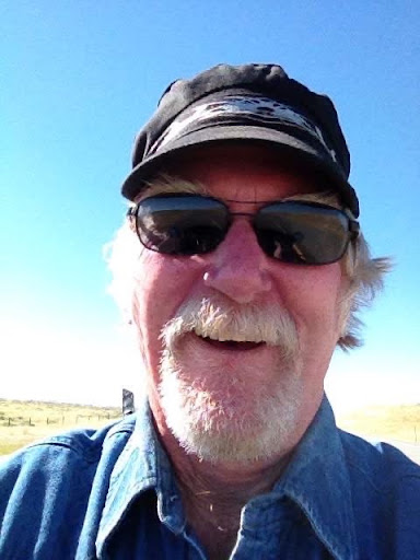 Blotar in his cap and sunglasses, grinning on an open road